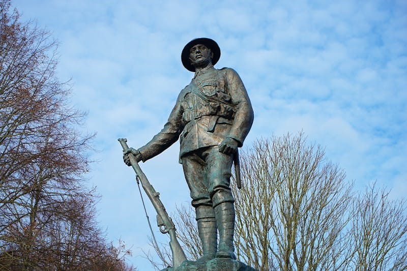Bronze World War I soldier statue in England on a clear day.