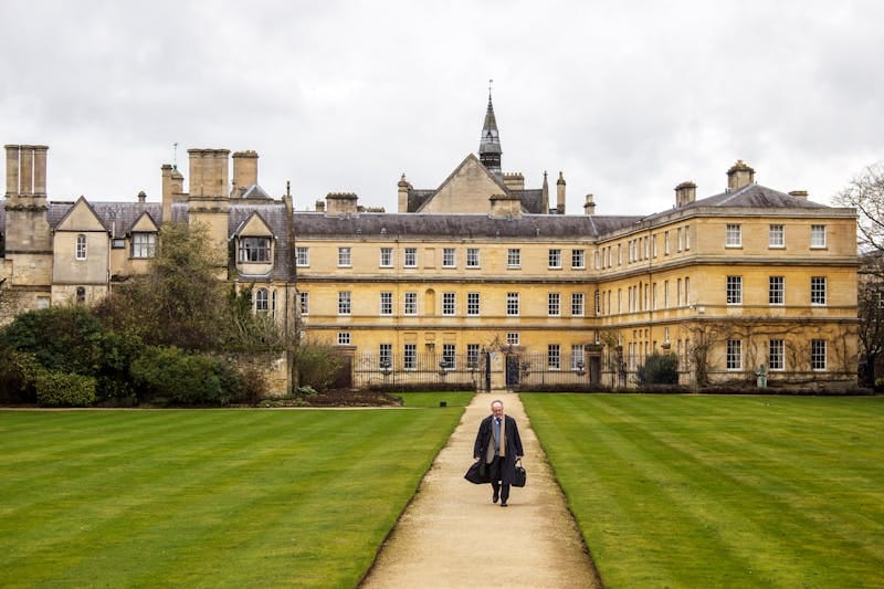 A scenic view of a historic building in Oxford, England, with a lush garden path.