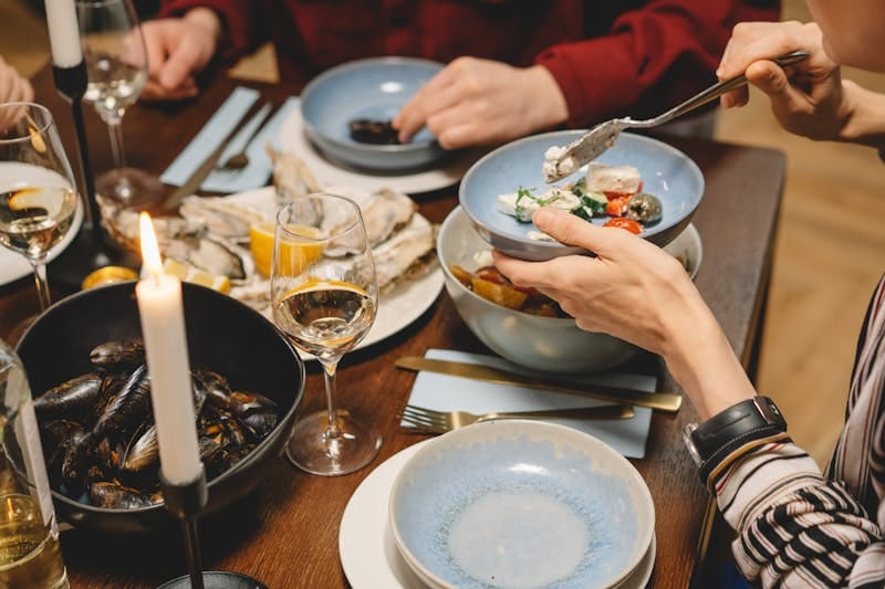 A close-up of a dinner setting featuring seafood, wine, and candles, creating a warm atmosphere.