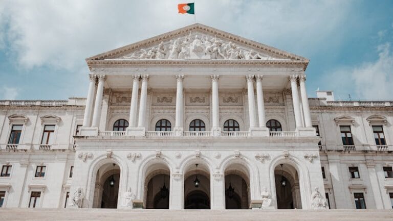 Front view of the historic São Bento Palace in Lisbon, showcasing its grand architecture and Portuguese flag.
