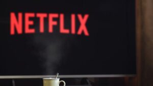 A steaming mug on a table in front of a TV displaying Netflix, creating a cozy indoor atmosphere.
