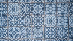 Aged wall covered with ceramic square shaped tile with many blue different ornaments